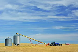 Agribusiness Gallery: Grain bins, tractor and auger near Beechy Saskatchewan, Canada