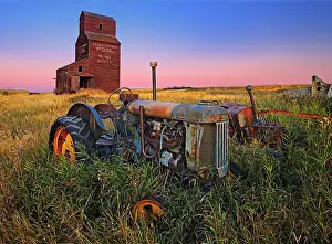 Grain elevator with old tractor at dawn Bents Saskatchewan, Canada