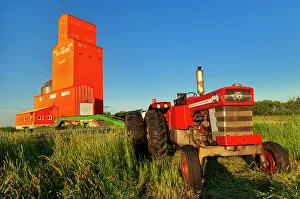 Tractor Prints: Grain elevator and tractor at sunrise. Carey, Manitoba, Canada