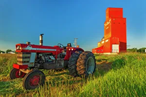 Tractor Prints: Grain elevator and tractor at sunrise. Carey, Manitoba, Canada