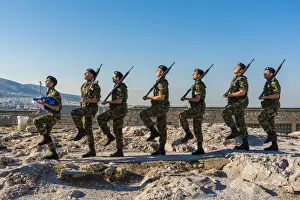 Greek army soldiers perform a ceremonial march on the Acropolis before raising