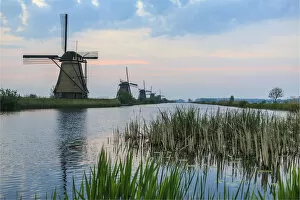 Images Dated 4th July 2016: Green grass frames the windmills reflected in the canal at dawn Kinderdijk Rotterdam
