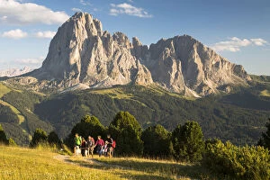 a group of hikers is walking in Val Gardena with the Langkofel and Plattkofel in the