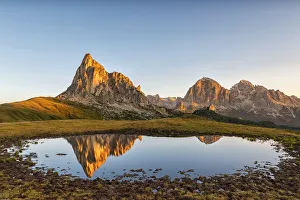 Gusela mountain at sunrise reflected in small lake, Giau Pass, Dolomites, Veneto, Italy Gusela mountain at sunrise reflected in small lake, Giau Pass, Dolomites, Veneto, Italy
