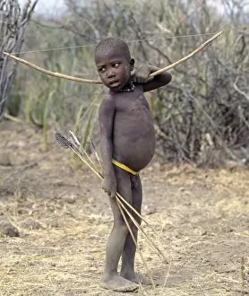 Hunter Gallery: A Hadza boy carrying a bow and arrows