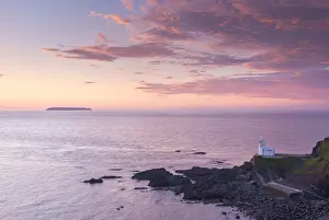 Hartland Point Lighthouse and Lundy Island beneath a colourful sunset, North Devon