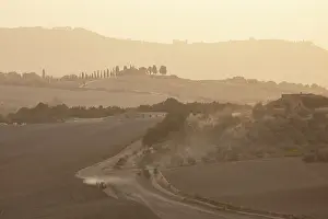 Pienza Prints: Hazy landscape at dusk, with tractor ploughing field