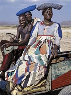 Traditional Attire Gallery: An Herero man and two women ride home in a donkey cart