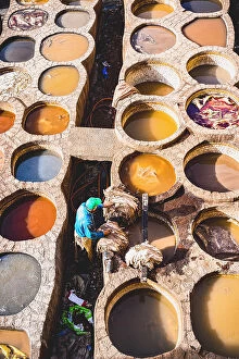 Morocco Collection: High angle view of man working at the vats of colours in the tannery of Fes, Morocco