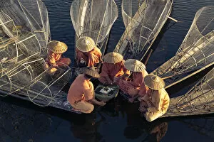 Males Collection: High angle view of traditional fishermen on Lake Inle having a supper on boats together