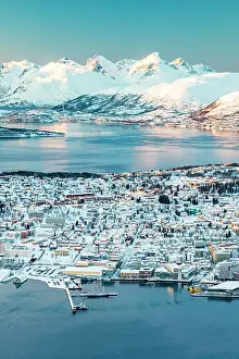 Rooftop Prints: High angle view of Tromso city and harbor covered with snow at sunset from Fjellheisen viewpoint