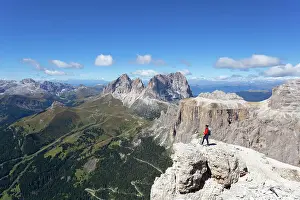 Sella Group Prints: A hiker admires Fassa Valley and Sassolungo Group from Sass Pordoi