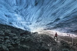 one hiker admiring one ice cave in Jokusarlon Glacier Lagoon area in winter time, Austurland, Iceland (MR)