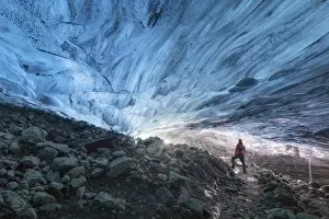 Artic Prints: one hiker admiring one ice cave in Jokusarlon Glacier Lagoon area in winter time