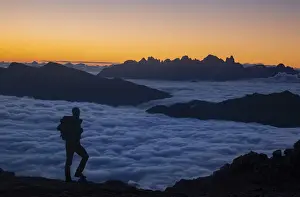 Trekker Prints: Hiker admiring sunrise in Dolomites mountains with Pale di San Martino group in