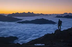 Trekker Prints: Hiker admiring sunrise from Latemar with Pale di San Martino group in background over a