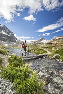 Trekkers Prints: Hiker crossing a stream Engadine Canton of Grisons Switzerland Europe