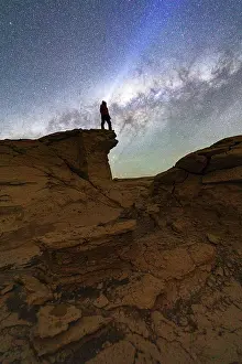 Night Sky Prints: Hiker with head torch pointing the starry sky