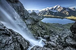 Waterfalls Collection: A hiker at lake Manzina who has just left the Tresero and the tops of St