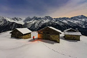 Torch Prints: Hiker with lamp admiring the stars over snowy mountains