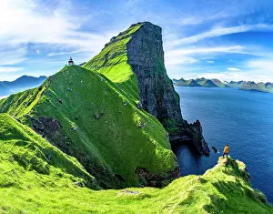 Enjoyment Prints: Hiker looking at Kallur lighthouse standing on green cliffs