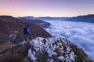 Above The Clouds Collection: Hiker over the top looks lake Como (ramo di Lecco) covered by the fog at sunrise