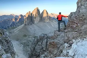 Lavaredo Prints: Hiker on the top of mount Paterno / Paternkofel looking the sunrise towards Tre Cime