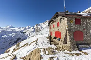 On Top Of Prints: Hiker photographing the snowy peaks from Citta di Bosco hut, Val Formazza