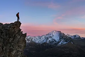 Admiring Prints: An hiker on a rock in Viola valley with a panoramic view at sunset