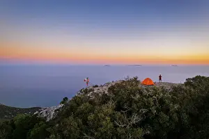Ponza Prints: Hiker stands on top of Circeo peak near his tent enjoying the view of Pontine islands