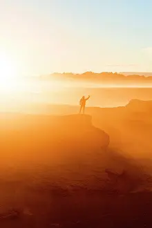 Exploration Prints: Hiker in sunrise mist snapping a selfie with smartphone