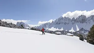 Snowshoes Prints: a hiker is walking with snowshoes into the Natural Park Puez Geisler with the Aferer