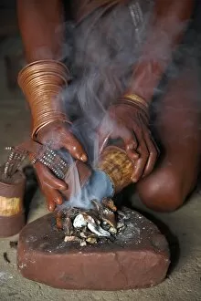 Indigenous People Collection: A Himba woman lights a small fire made of woodshavings