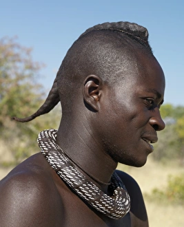 A Himba youth with his hair styled in a long plait, known as ondatu