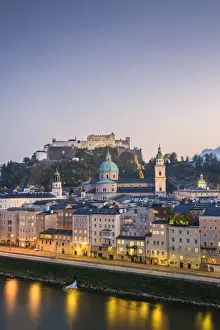 Historical old town of Salzburg reflected in Salzach river at dusk with Hohensalzburg