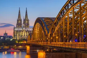 Hohenzoller Bridge over River Rhine and Cologne Cathedral at dusk in Cologne city