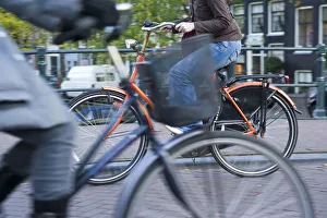 Bicylces Gallery: Holland, Amsterdam, riding a bicycle over a canal bridge