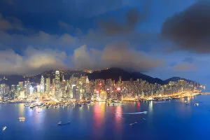Hong Kong, city overview by night with Victoria harbour and peak in the background