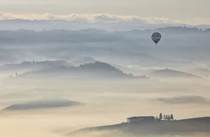 Borgo Prints: An hot air balloon flies over vineyards and mist during autumn, Cuneo, Langhe e Roero