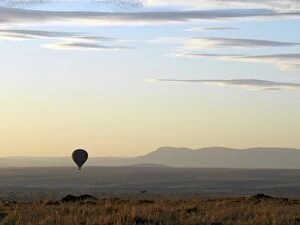 Images Dated 1st January 2000: A hot air balloon floating over the Masai Mara Game Reserve at daybreak