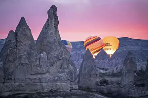 Hot Air Balloons rising at sunrise in Rose Valley, Cappadocia, Turkey