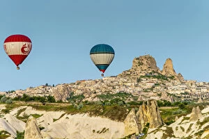 Images Dated 4th August 2015: Hot air balloons at sunrise with mountain village of Ortahisar in the background