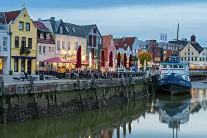 Dwellings Gallery: Houses with colorful facades on Hafenstrasse and anchored boat, Husum, Nordfriesland