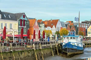 Dwellings Gallery: Houses with colorful facades on Hafenstrasse and boat at low tide, Husum, Nordfriesland