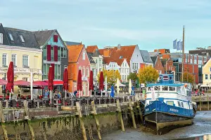 Husum Prints: Houses with colorful facades on Hafenstrasse and boat at low tide