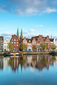Houses on riverfront of Trave river with towers of St. Marienkirche church in background, Lubeck, UNESCO, Schleswig-Holstein, Germany
