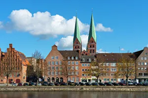 Houses on riverfront of Trave river with towers of St. Marienkirche church in background, Lubeck, UNESCO, Schleswig-Holstein, Germany