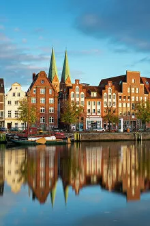 Images Dated 3rd January 2023: Houses on riverfront of Trave river with towers of St. Marienkirche church in background at