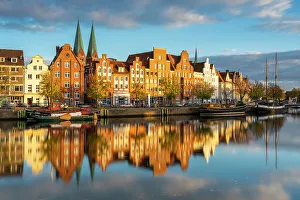 Images Dated 3rd January 2023: Houses on riverfront of Trave river with towers of St. Marienkirche church in background at