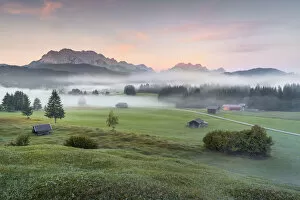 Mountainscape Collection: humped meadows with wafts of mist at sunrise and Karwendel Range and Zugspitz-Massif
